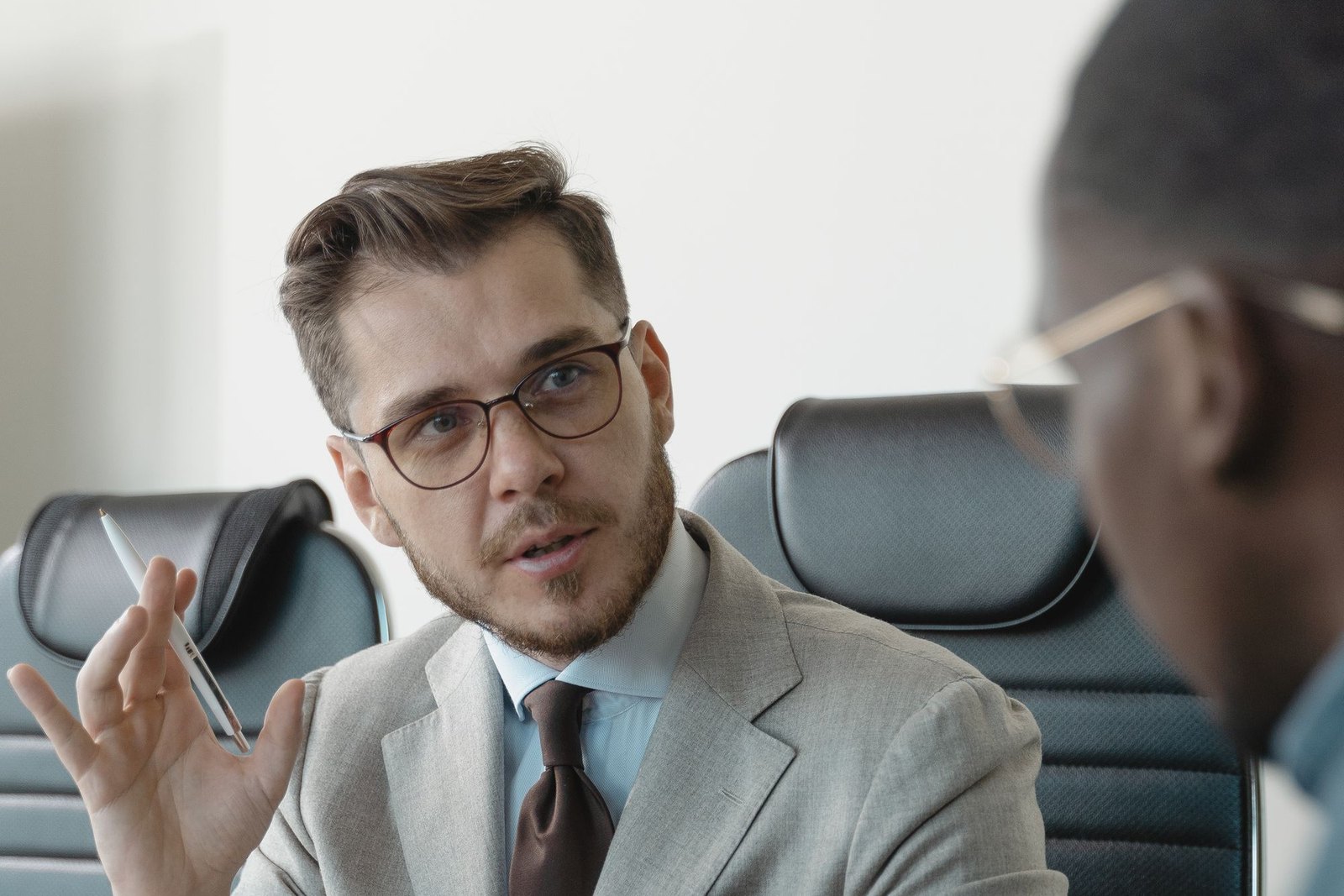 An executive leading a focused one-on-one coaching conversation across a boardroom desk
