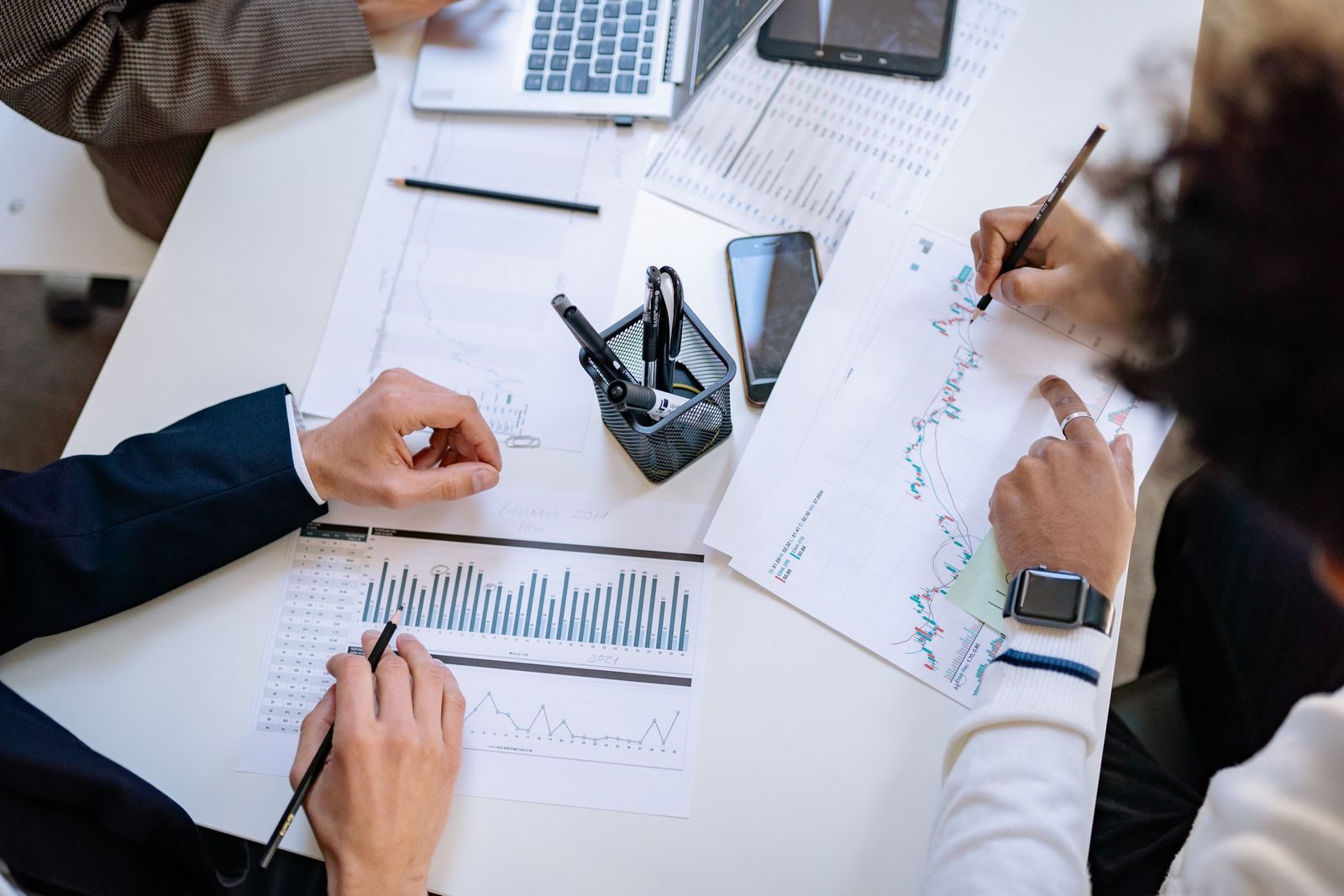 Consultants analyzing financial charts and performance data at a desk