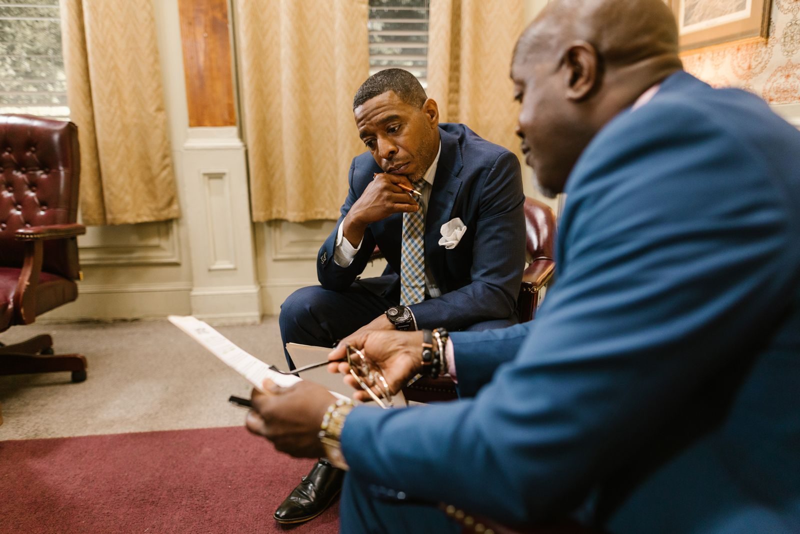 Two senior executives in a one-on-one conversation reviewing a document