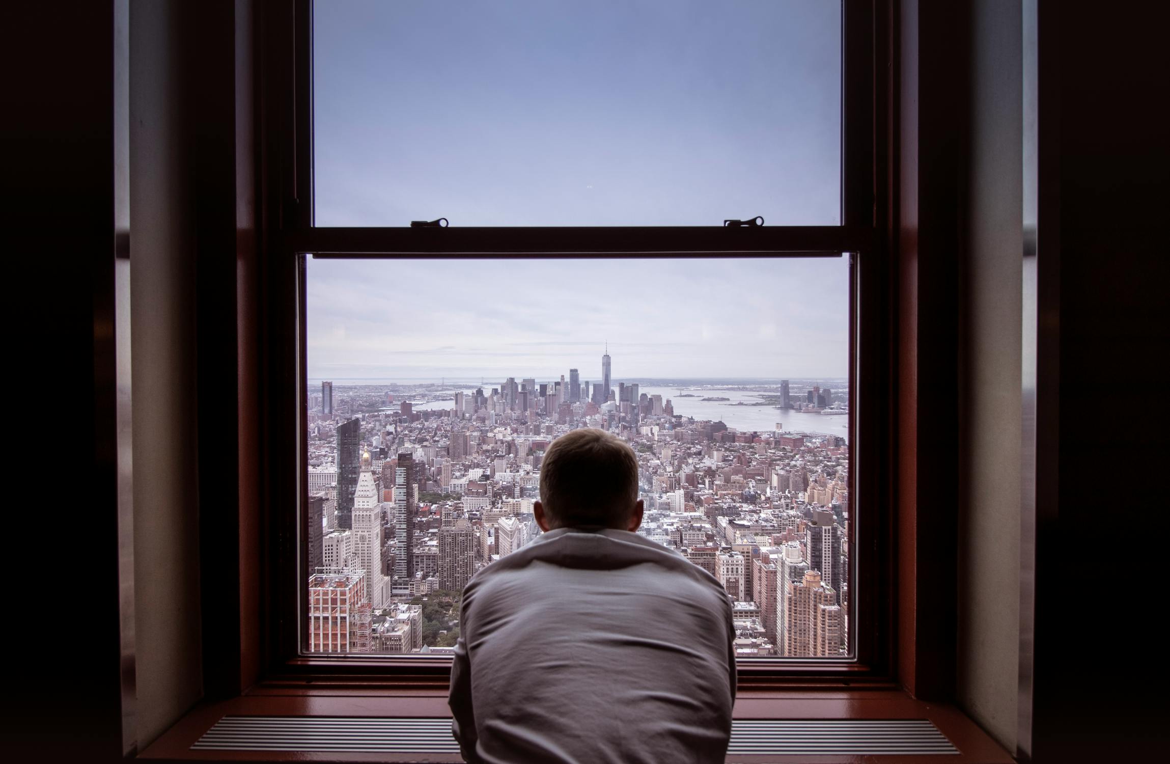 Professional looking out at city skyline from high-rise office