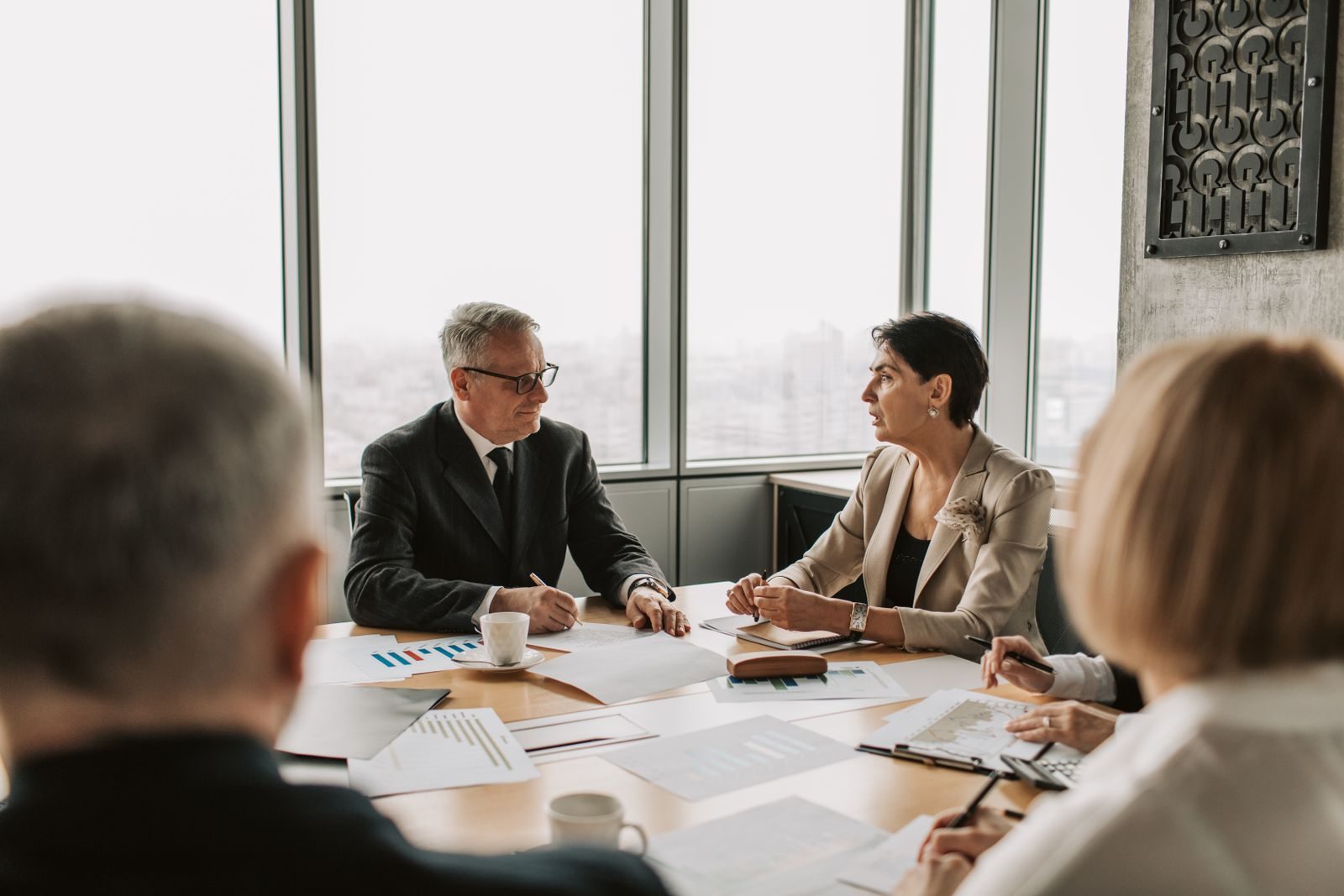 Senior executives in a boardroom discussing a leadership development decision
