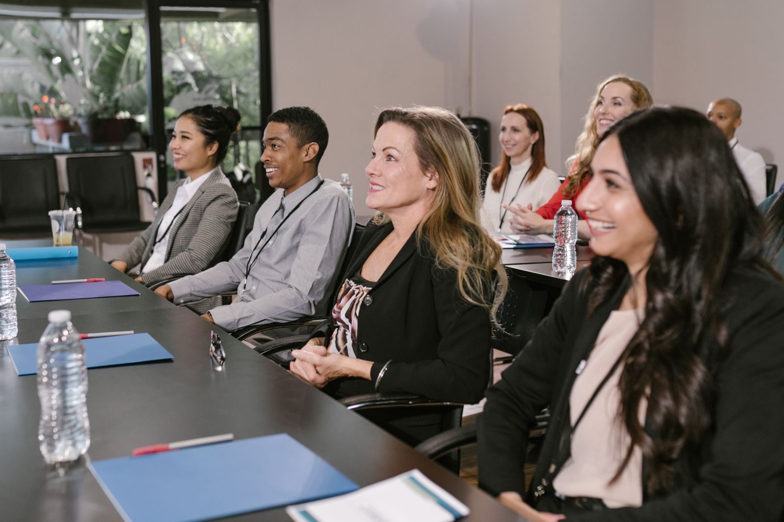 A leadership team seated along a boardroom table during a facilitated coaching session