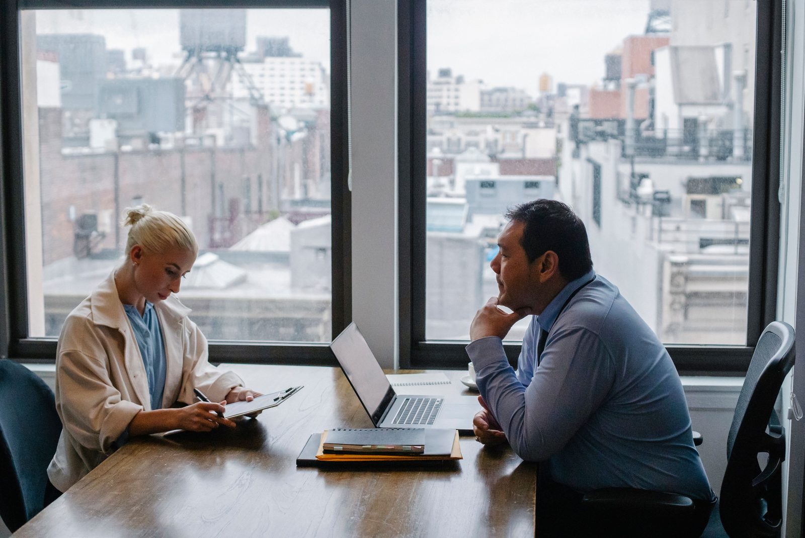 Two senior leaders in a private glass-walled meeting room