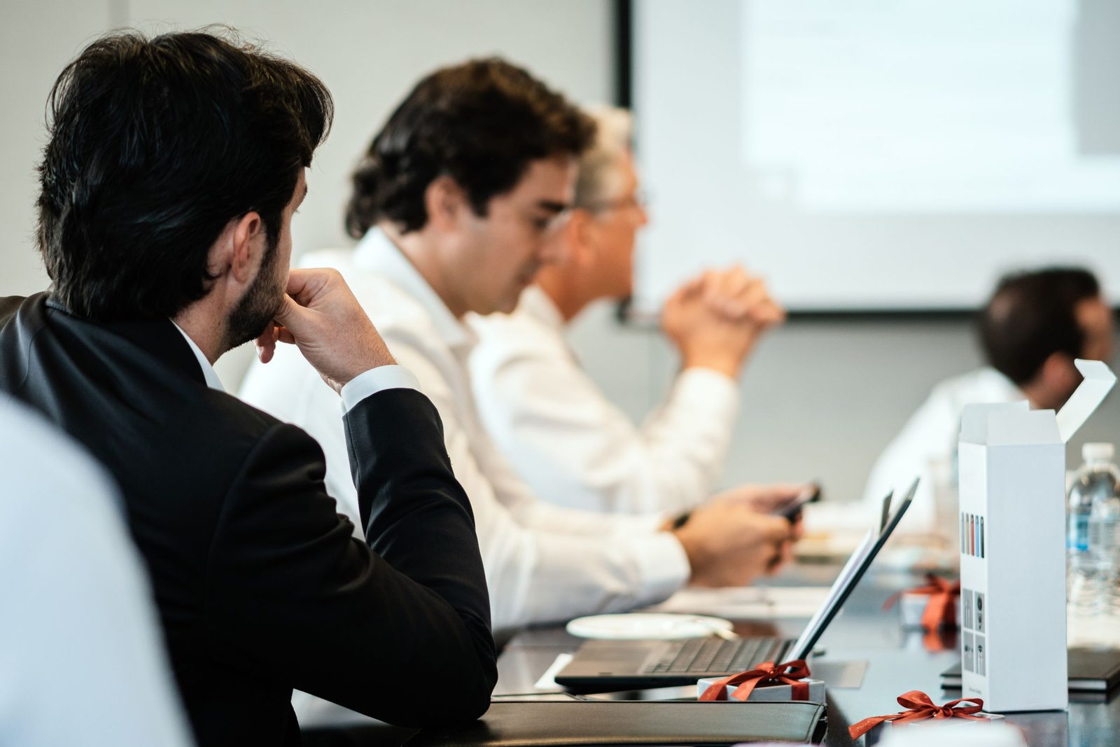 A cohort of senior leaders seated along a boardroom table during a corporate leadership session