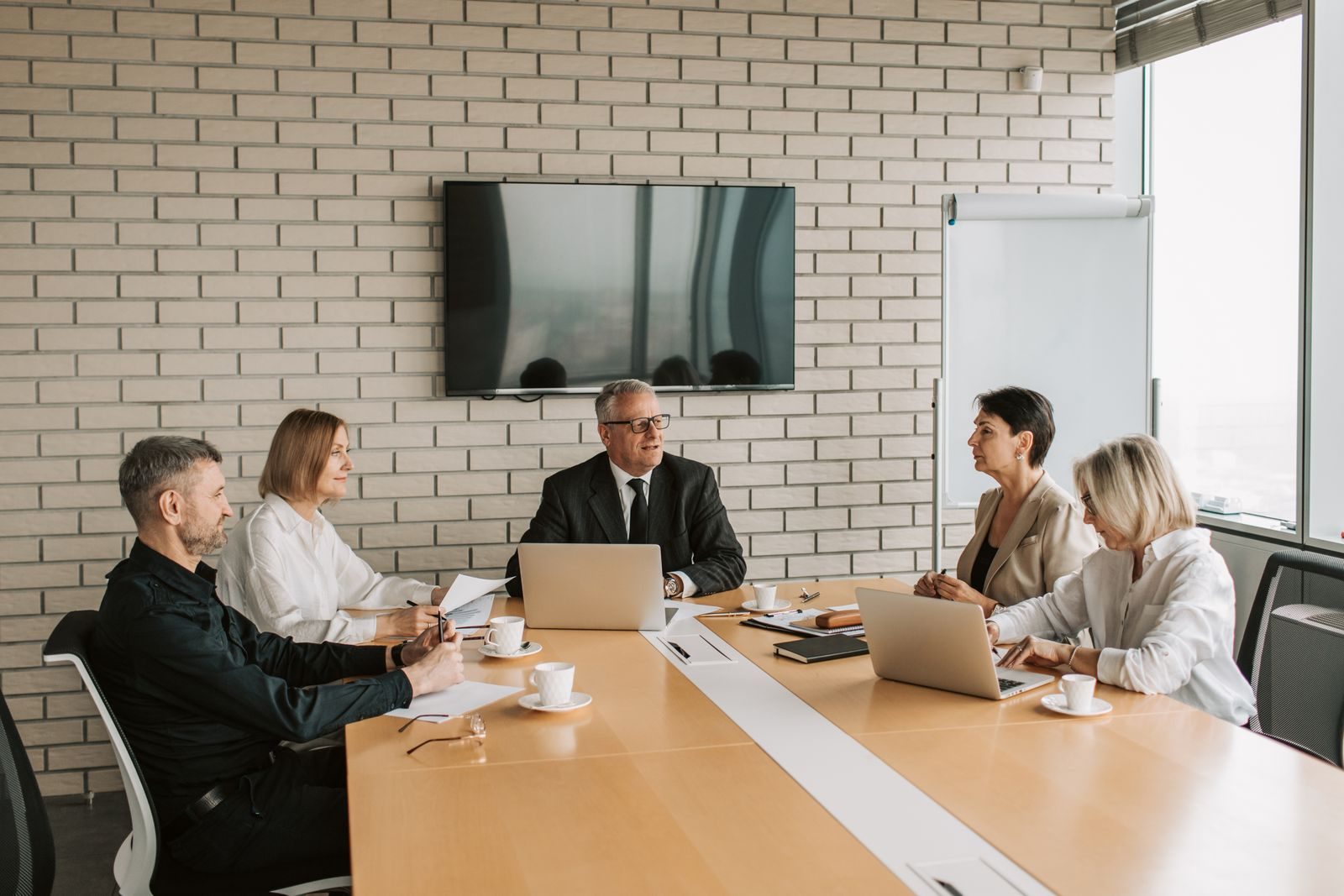 A senior leadership team meeting around a boardroom table