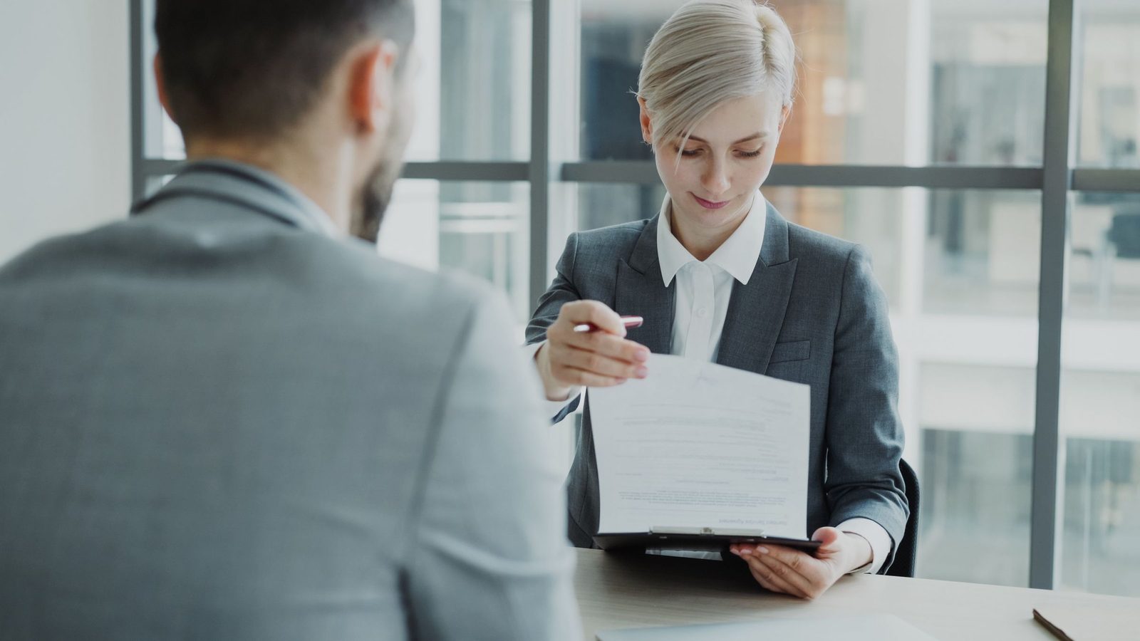 Two executives reviewing a written proposal across a boardroom table