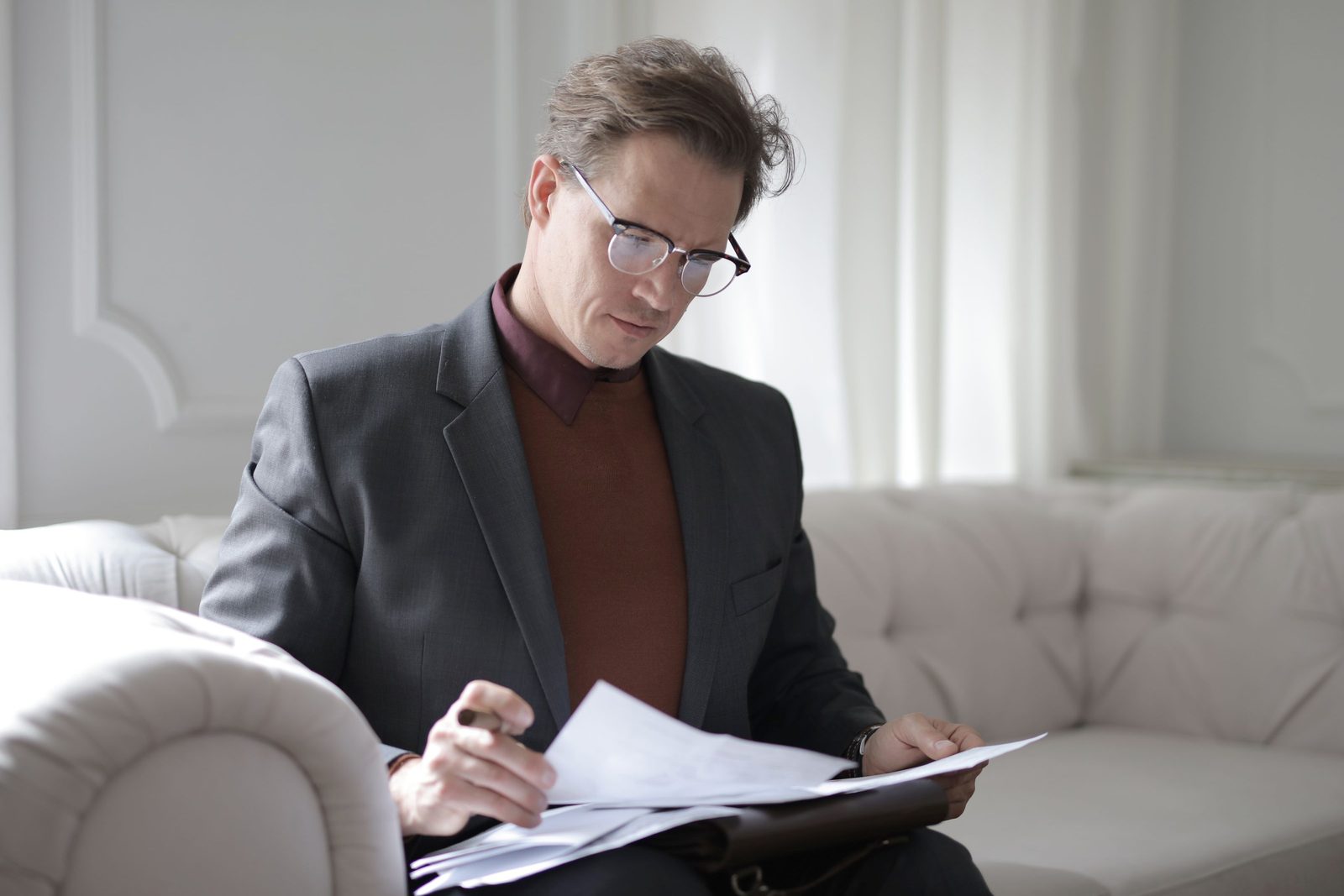 A senior executive in a suit reviewing documents with a focused expression