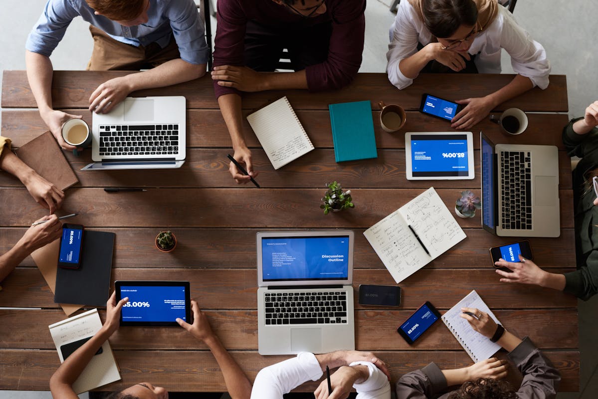 Executive team collaborating around a conference table with laptops and data